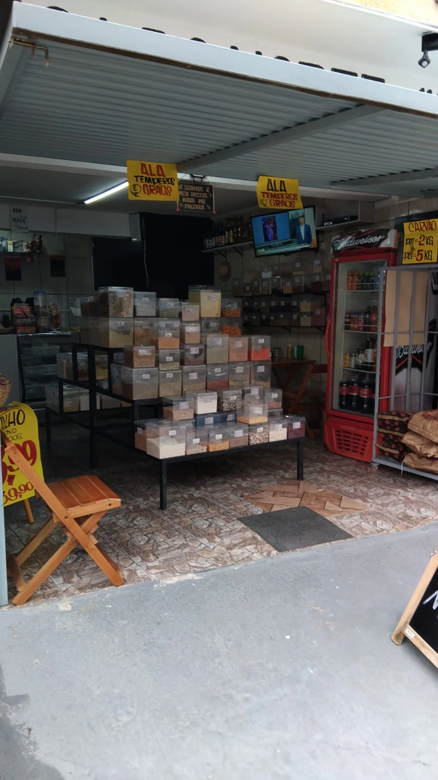 Banquinho rústico com cestos de palha contendo produtos da roça, em ambiente de loja artesanal